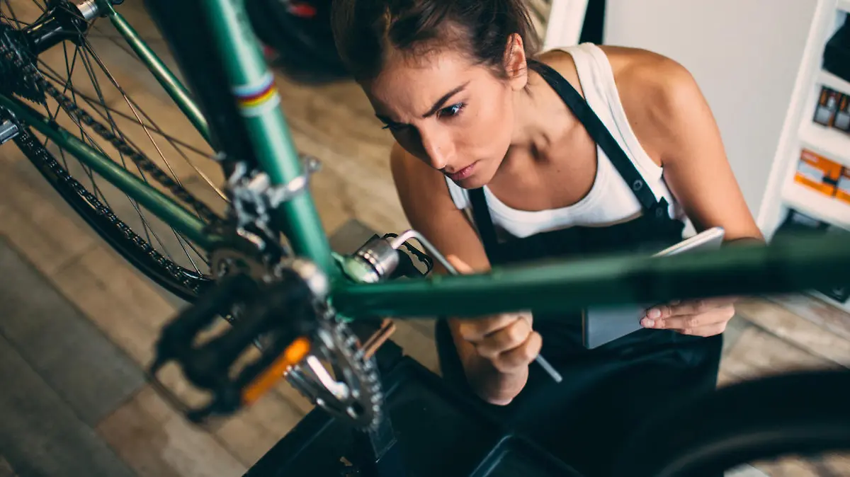 Frau macht Fahrrad fit für den Frühling