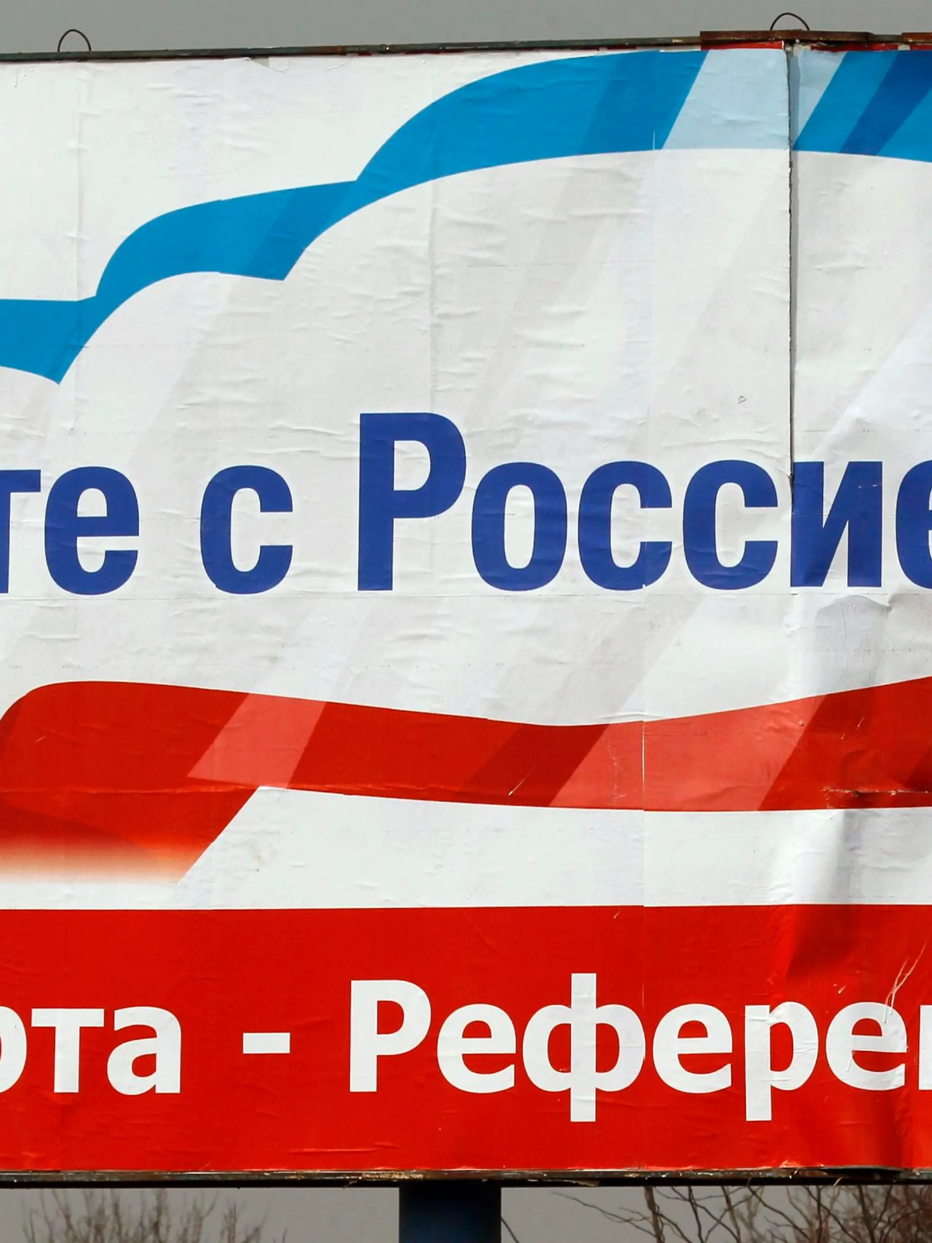 A worker puts up a poster that reads, "Together with Russia. March 16 - referendum", in the centre of Simferopol, March 12, 2014. Crimea will soon take ownership of Ukrainian state companies on its territory, its first deputy prime minister said on Wednesday, pushing forward with steps to cement the region's independence before a referendum on joining Russia.    REUTERS/Vasily Fedosenko (UKRAINE - Tags: POLITICS ELECTIONS)