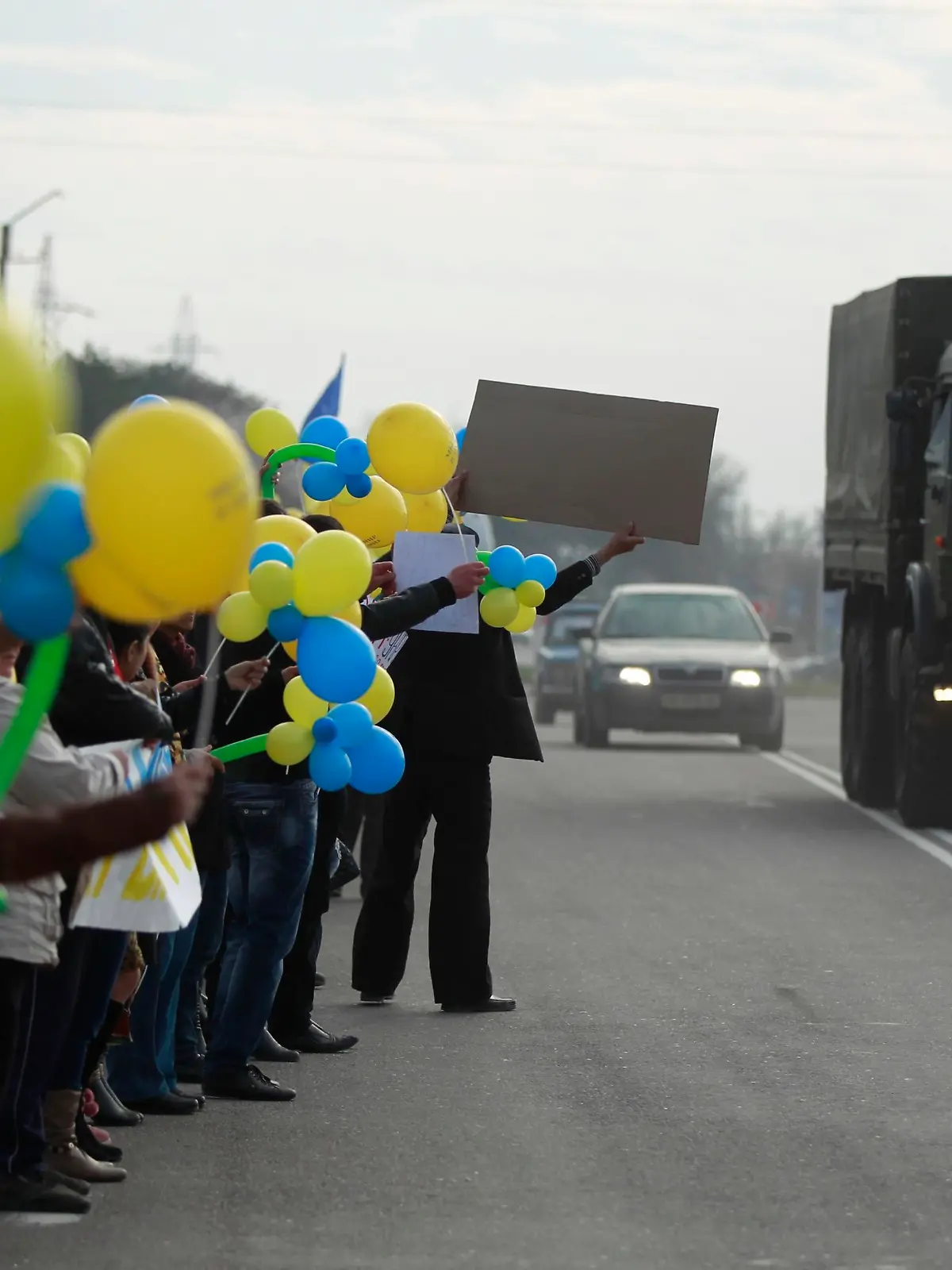 People react to a military truck, believed to be Russian, during a pro-Ukrainian rally in Bakhchisaray March 14, 2014. Russia shipped more troops and armour into Crimea on Friday and repeated its threat to invade other parts of Ukraine, showing no sign of listening to Western pleas to back off from the worst confrontation since the Cold War. REUTERS/David Mdzinarishvili (UKRAINE - Tags: POLITICS CIVIL UNREST)
