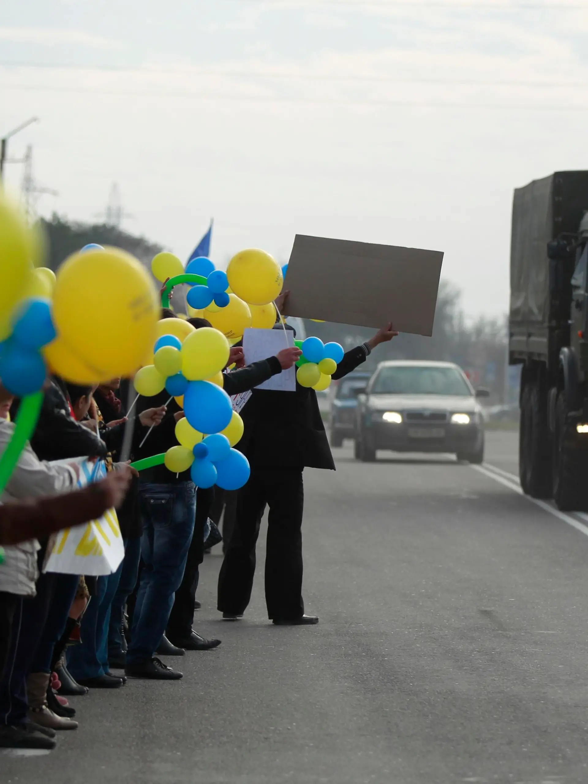 People react to a military truck, believed to be Russian, during a pro-Ukrainian rally in Bakhchisaray March 14, 2014. Russia shipped more troops and armour into Crimea on Friday and repeated its threat to invade other parts of Ukraine, showing no sign of listening to Western pleas to back off from the worst confrontation since the Cold War. REUTERS/David Mdzinarishvili (UKRAINE - Tags: POLITICS CIVIL UNREST)