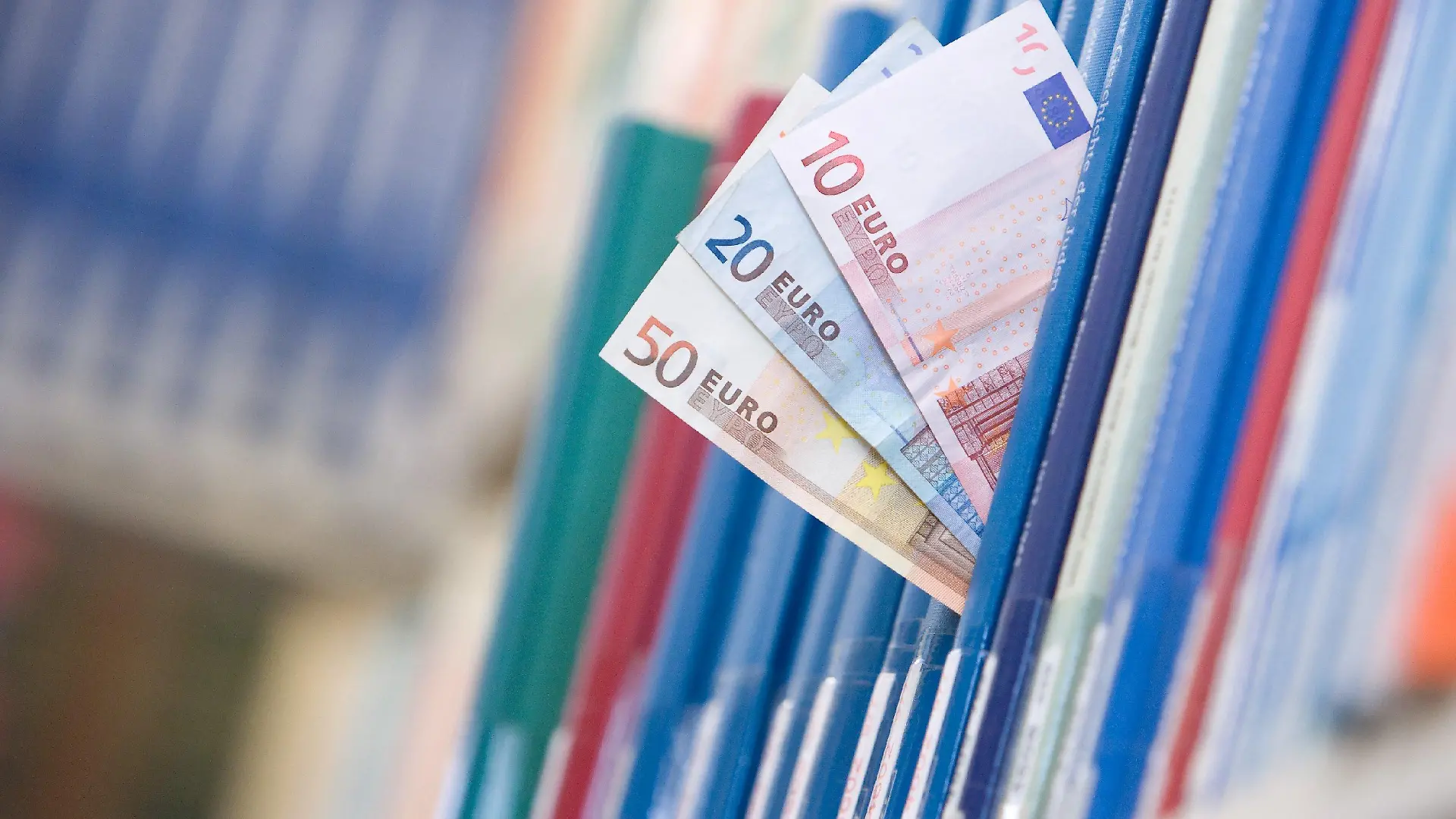 (ILLUSTRATION) Geldscheine in der Summe von 80 Euro stecken am Mittwoch (03.11.2009) in der Bibliothek der Universität Osnabrück zwischen Büchern in einem Regal. Nur vier Prozent der Studenten finanzieren sich über ein Stipendium, so eine Studie des Instituts für Demoskopie Allensbach. Neben einer finanziellen Unterstützung werden Stipendiaten bei Auslandsaufenthalten, Praktika oder Sprachkursen unterstützt. Foto: Friso Gentsch dpa/lni (zu dpa/lni-KORR.: "Ohne Geldsorgen studieren - Stipendien für Studenten" vom 06.11.2009) +++(c) dpa - Bildfunk+++