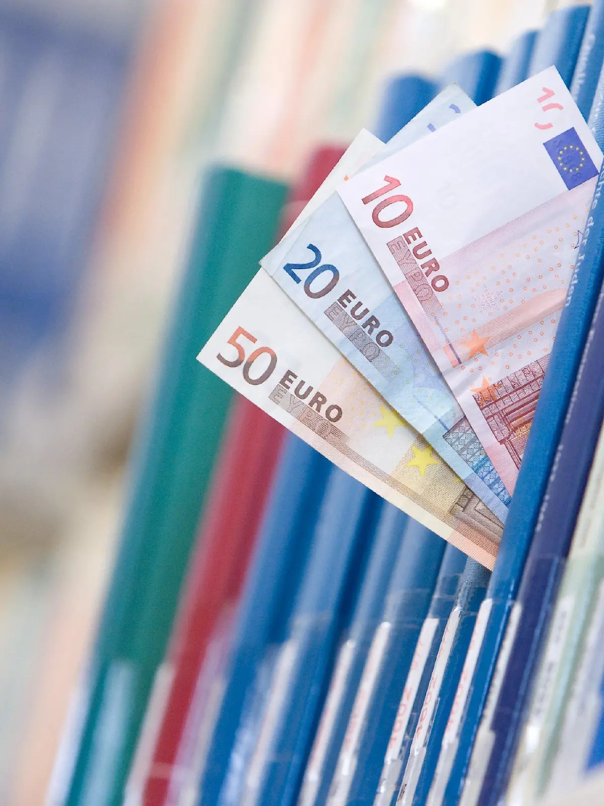 (ILLUSTRATION) Geldscheine in der Summe von 80 Euro stecken am Mittwoch (03.11.2009) in der Bibliothek der Universität Osnabrück zwischen Büchern in einem Regal. Nur vier Prozent der Studenten finanzieren sich über ein Stipendium, so eine Studie des Instituts für Demoskopie Allensbach. Neben einer finanziellen Unterstützung werden Stipendiaten bei Auslandsaufenthalten, Praktika oder Sprachkursen unterstützt. Foto: Friso Gentsch dpa/lni (zu dpa/lni-KORR.: "Ohne Geldsorgen studieren - Stipendien für Studenten" vom 06.11.2009)  +++(c) dpa - Bildfunk+++