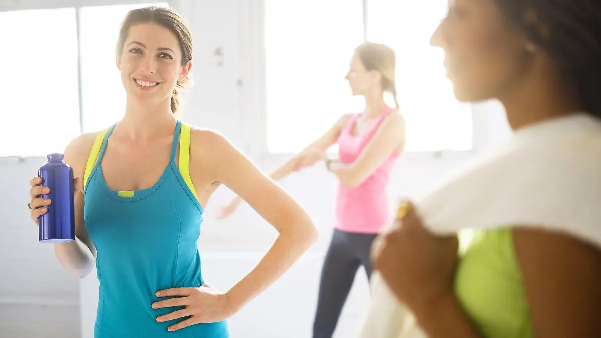 Portrait der Frau mit Sportgetraenk an der Gymnastik, Portrait of woman holding sport drink at gym | Verwendung weltweit, Keine Weitergabe an Wiederverkäufer.