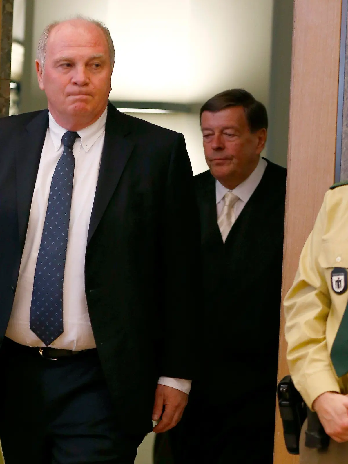 Der Präsident des FC Bayern München, Uli Hoeneß (l), kommt am 11.03.2014, dem zweiten Verhandlungstag, als Angeklagter im Landgericht München II (Bayern) in den Gerichtssaal. Hoeneß soll im großen Stil Steuern hinterzogen haben.  Foto: Michael Dalder/dpa +++(c) dpa - Bildfunk+++