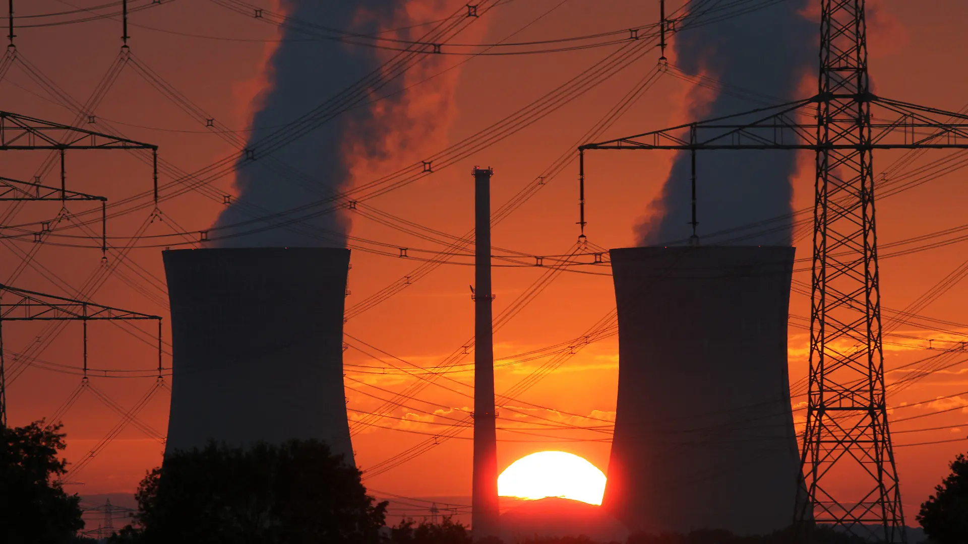 ARCHIV - Glühend rot ist der Himmel beim Sonneuntergang am Sonntagabend (21.08.2011) hinter den Kühltürmen des Atomkraftwerks Grafenrheinfeld (Unterfranken). Der Ausstoß von Treibhausgasen steigt dramatisch an, die Erderwärmung könnte unbeherrschbar werden. Dennoch scheint ein Durchbruch für mehr globalen Klimaschutz in einer Woche beim UN-Gipfel in Durban kaum möglich. Überlegt wird schon, einfach die Sonne abzuschirmen. Foto: Daniel Karmann dpa/lby (zu (THEMENPAKET Klimagipfel - zum 28. November, Letzte Ausfahrt Sonnenabschirmung?) +++(c) dpa - Bildfunk+++