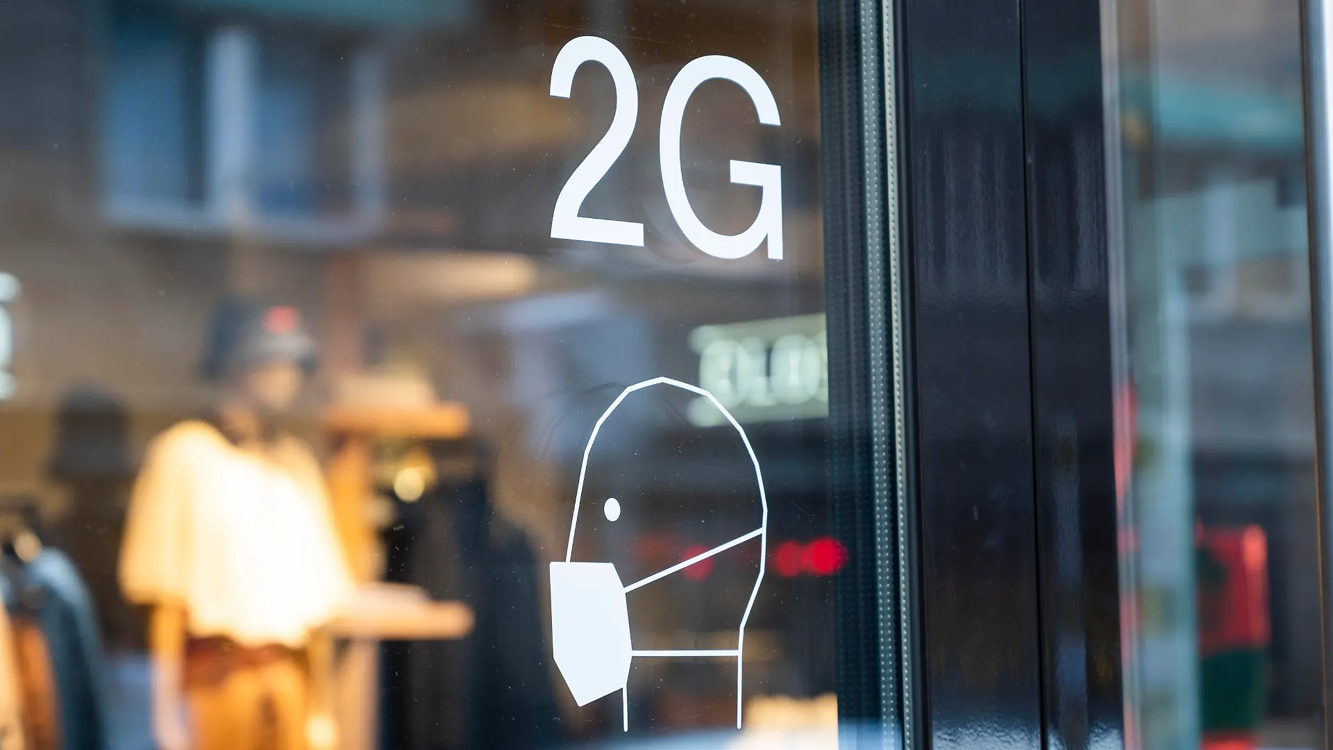 ARCHIV - 22.12.2021, Berlin: An der Tür an einem Ladengeschäft sind Hinweise zu den Coronaregeln ausgeschildert. Wegen der 2G-Regelung im Einzelhandel sind aus Sicht des Mittelstandsverbundes die Umsätze von Unternehmen unter Druck geraten. (zu dpa «Verband: 2G-Regelung im Handel könnte Konjunkturbremse werden») Foto: Christophe Gateau/dpa +++ dpa-Bildfunk +++