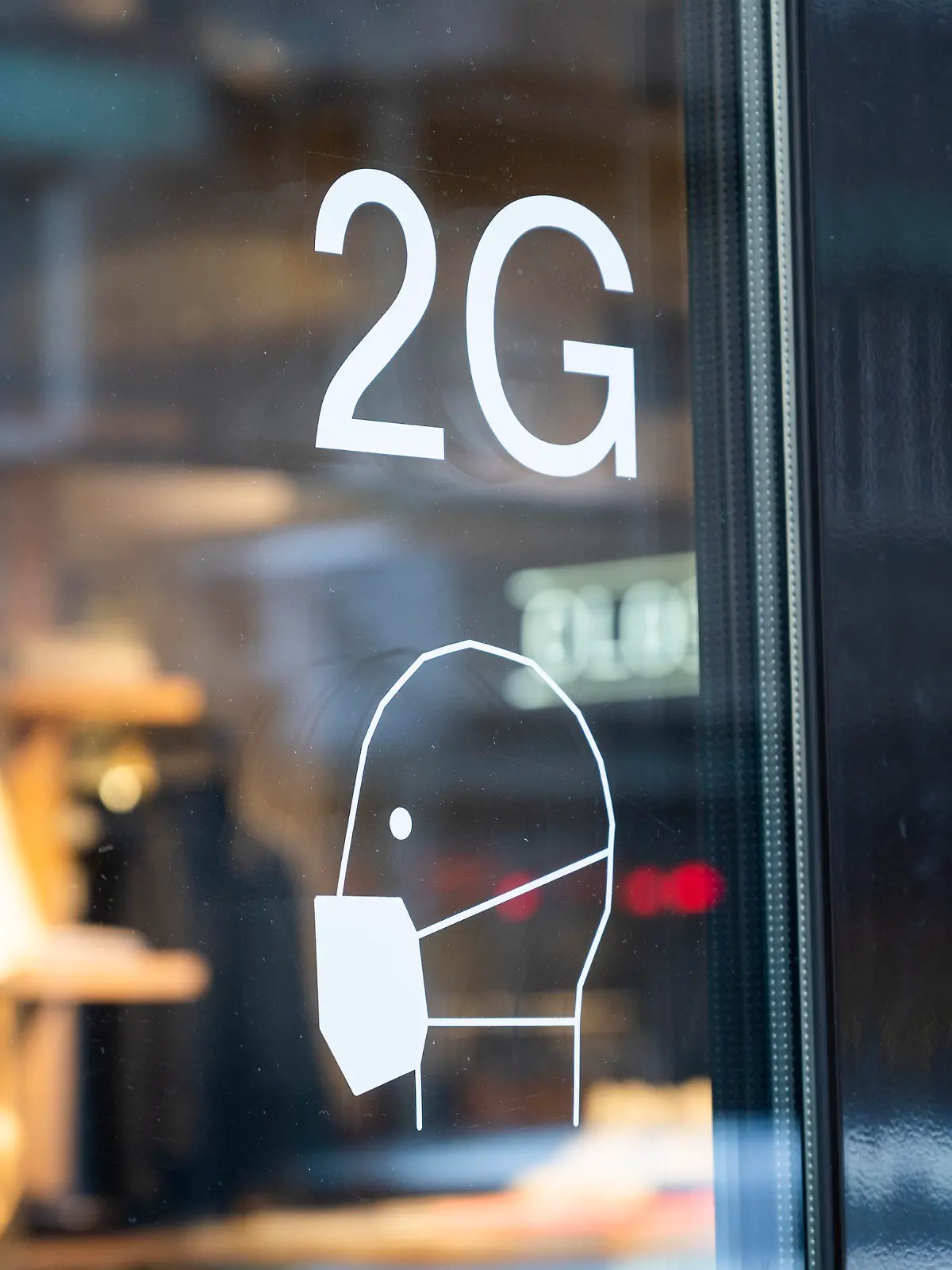 ARCHIV - 22.12.2021, Berlin: An der Tür an einem Ladengeschäft sind Hinweise zu den Coronaregeln ausgeschildert. Wegen der 2G-Regelung im Einzelhandel sind aus Sicht des Mittelstandsverbundes die Umsätze von Unternehmen unter Druck geraten. (zu dpa «Verband: 2G-Regelung im Handel könnte Konjunkturbremse werden») Foto: Christophe Gateau/dpa +++ dpa-Bildfunk +++