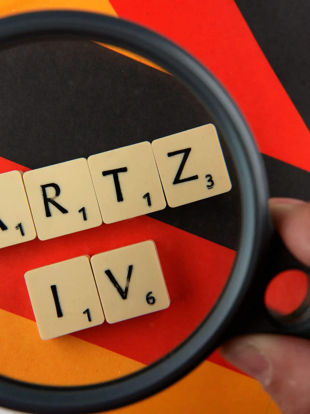 ARCHIV - ILLUSTRATION - Unter einer Lupe ist in Schwerin der Schriftzug "Hartz IV" zu sehen (Foto vom 23.05.2006). Jeder zweite Hartz-Empfänger erhält nach Angaben der Bundesagentur für Arbeit (BA) bereits seit vier Jahren Geld vom Jobcenter. Von den sechs Millionen Hartz-IV-Betroffenen seien im Jahr 2012 mehr als 2,8 Millionen oder 46,5 Prozent auf die sogenannte Grundsicherung angewiesen, berichtete BA-Sprecherin Anja Huth und bestätigte damit einen entsprechenden Bericht der «Bild»-Zeitung (Freitag, 12.07.2013). Foto: Jens Büttner/dpa (zu dpa-Meldung vom 12.07.2013) +++(c) dpa - Bildfunk+++