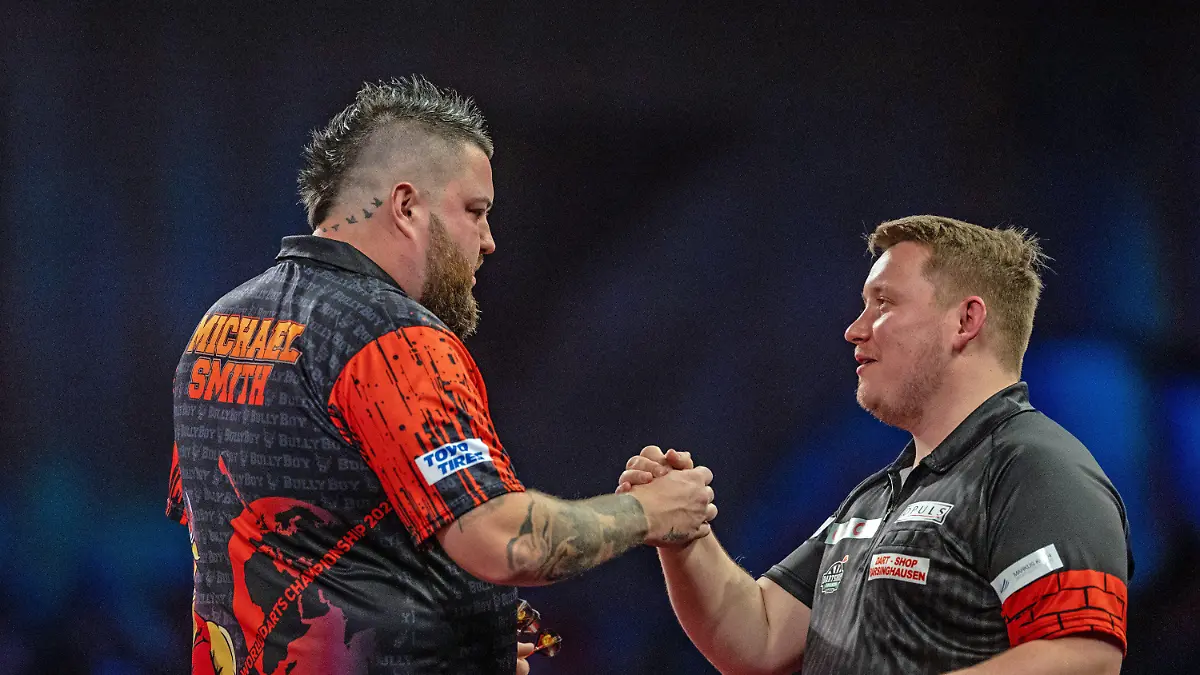 28.12.2022, Großbritannien, London: Darts: WM, 3. Runde, 3. Runde. Schindler (Deutschland) - Smith (England). Michael Smith (l) gibt nach seinem Sieg Martin Schindler die Hand. Foto: Steven Paston/PA Wire/dpa +++ dpa-Bildfunk +++
