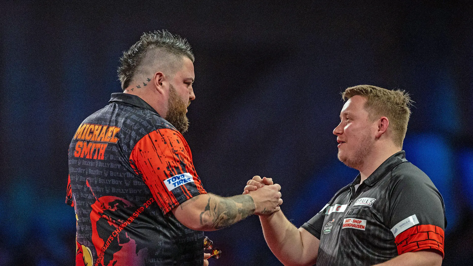 28.12.2022, Großbritannien, London: Darts: WM, 3. Runde, 3. Runde. Schindler (Deutschland) - Smith (England). Michael Smith (l) gibt nach seinem Sieg Martin Schindler die Hand. Foto: Steven Paston/PA Wire/dpa +++ dpa-Bildfunk +++