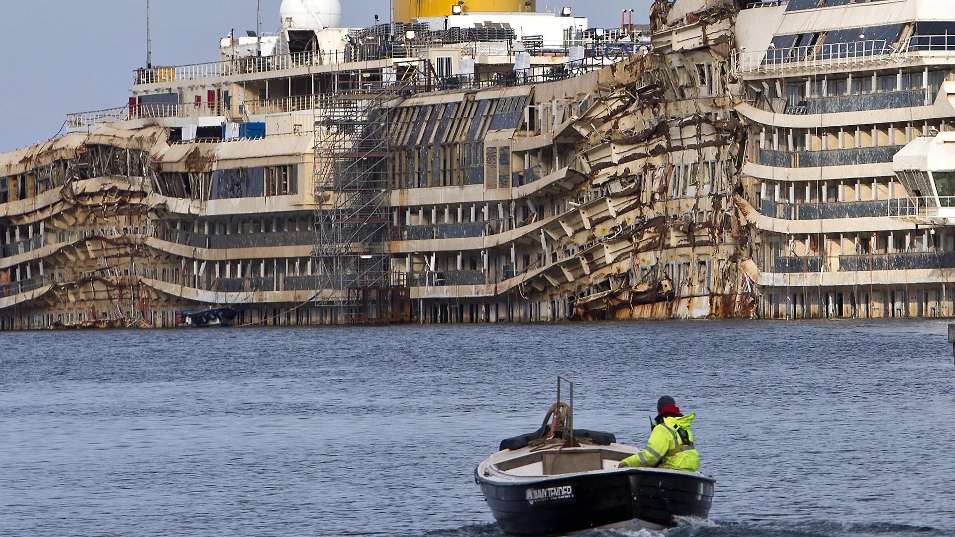 File - epa04018983 A small vessel passes the wreckage of the ill-fated multi-storey Costa Concordia liner in Giglio Porto, northern Italy 13 January 2014 on the second anniversary of the Costa Concordia wreck. Of the 3,229 passengers and 1,023 crew known to have been aboard, 30 people died. EPA/STF (zu dpa "Hamburger Experten an Bord des «Costa»-Wracks" am 05.03.2014) +++(c) dpa - Bildfunk+++