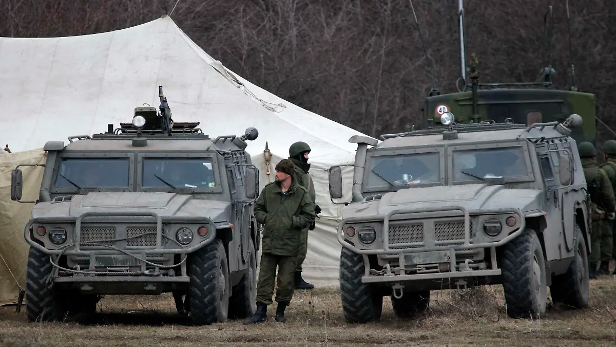 Military vehicles, believed to be property of Russian army, are seen near the territory of a Ukrainian military unit in the village of Perevalnoye outside Simferopol March 2, 2014. Ukraine mobilised for war on Sunday and Washington threatened to isolate Russia economically, after President Vladimir Putin declared he had the right to invade his neighbour, creating Moscow's biggest confrontation with the West since the Cold War. Russian forces have already bloodlessly seized Crimea - an isolated Black Sea peninsula where Moscow has a naval base. On Sunday they surrounded several small Ukrainian military outposts there and demanded the Ukrainian troops disarm. Some refused, leading to standoffs, although no shots were fired. REUTERS/Vasily Fedosenko (UKRAINE - Tags: POLITICS MILITARY CIVIL UNREST)