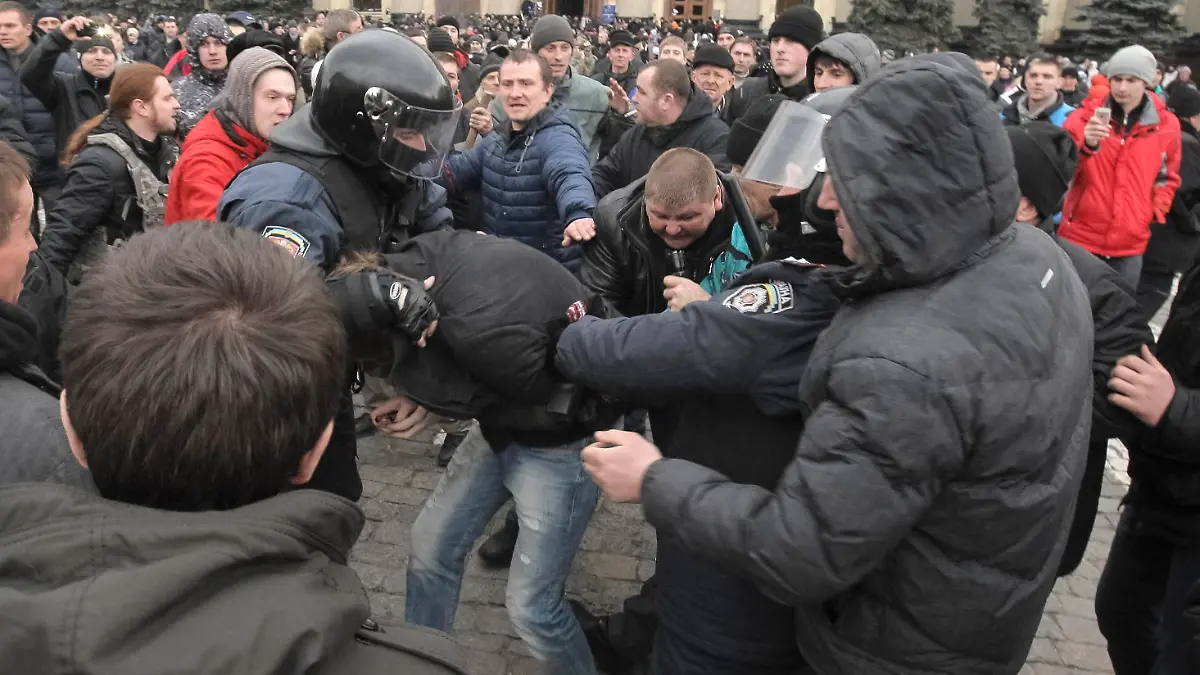 Pro-Russian protesters clash with a supporter (C) of Ukraine's new government in central Kharkiv March 1, 2014. Pro-Russia activists clashed with supporters of the new Ukrainian government in the eastern Ukrainian city of Kharkiv on Saturday and tried to seize the regional governor's headquarters, Interfax news agency said.   REUTERS/Stringer  (UKRAINE - Tags: POLITICS CIVIL UNREST)