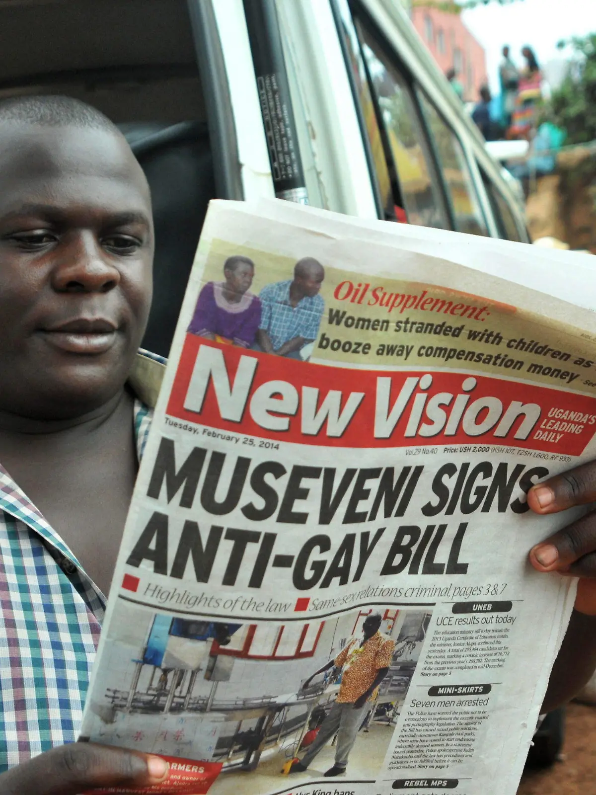 epa04100002 An Ugandan man reads a daily newspaper on 25 February 2014 with headlines and images of Ugandan President Yoweri Museveni signing the anti-gay legislation in Kampala, Uganda, 24 February 2014. A controversial bill that introduces lengthy prison sentences for people who engage in homosexual acts was signed into law by Ugandan President Yoweri Museveni yesterday. The law, which has been strongly criticized by Western governments and human rights groups, punishes first-time offenders with up to 14 years in jail. People convicted of same-sex intercourse with a disabled person or a minor, as well as HIV-positive people caught engaging in homosexual acts, face life imprisonment. The law also makes it a crime not to report gay people. For the first time, lesbians are also targeted by legislation. EPA/RONALD KABUUBI +++(c) dpa - Bildfunk+++
