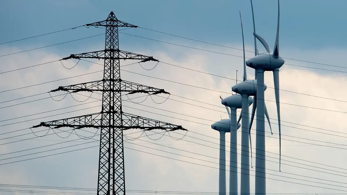 Windräder und ein Strommast stehen am 21.02.2014 bei Sehnde-Müllingen in der Region Hannover (Niedersachsen). Für das längste Stromnetzprojekt Deutschlands liegen die Trassenpläne auf dem Tisch. Die «Hauptschlagader der Energiewende» soll ab 2022 Windstrom von Schleswig-Holstein über Niedersachsen, Nordrhein-Westfalen und Hessen nach Bayern bringen. Die Nord-Süd-Stromtrasse wäre 800 Kilometer lang. Foto: Julian Stratenschulte/dpa +++(c) dpa - Bildfunk+++