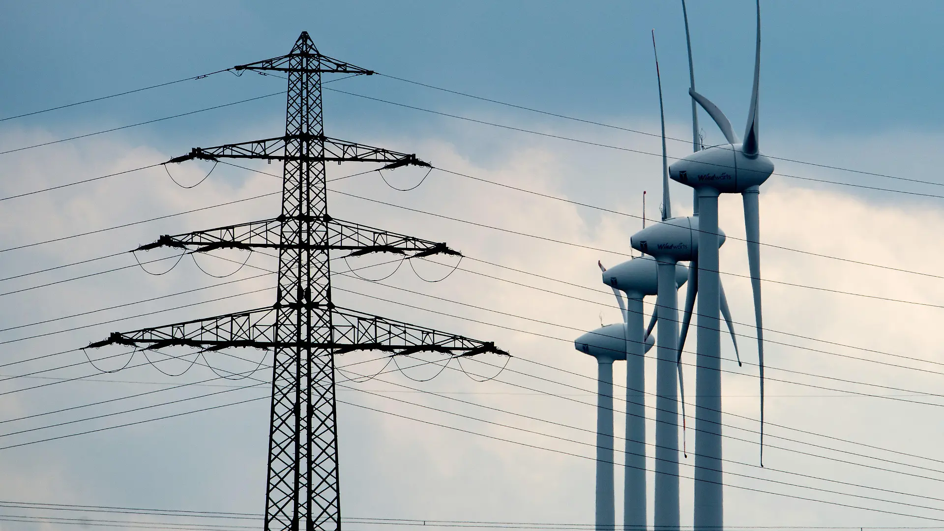 Windräder und ein Strommast stehen am 21.02.2014 bei Sehnde-Müllingen in der Region Hannover (Niedersachsen). Für das längste Stromnetzprojekt Deutschlands liegen die Trassenpläne auf dem Tisch. Die «Hauptschlagader der Energiewende» soll ab 2022 Windstrom von Schleswig-Holstein über Niedersachsen, Nordrhein-Westfalen und Hessen nach Bayern bringen. Die Nord-Süd-Stromtrasse wäre 800 Kilometer lang. Foto: Julian Stratenschulte/dpa +++(c) dpa - Bildfunk+++