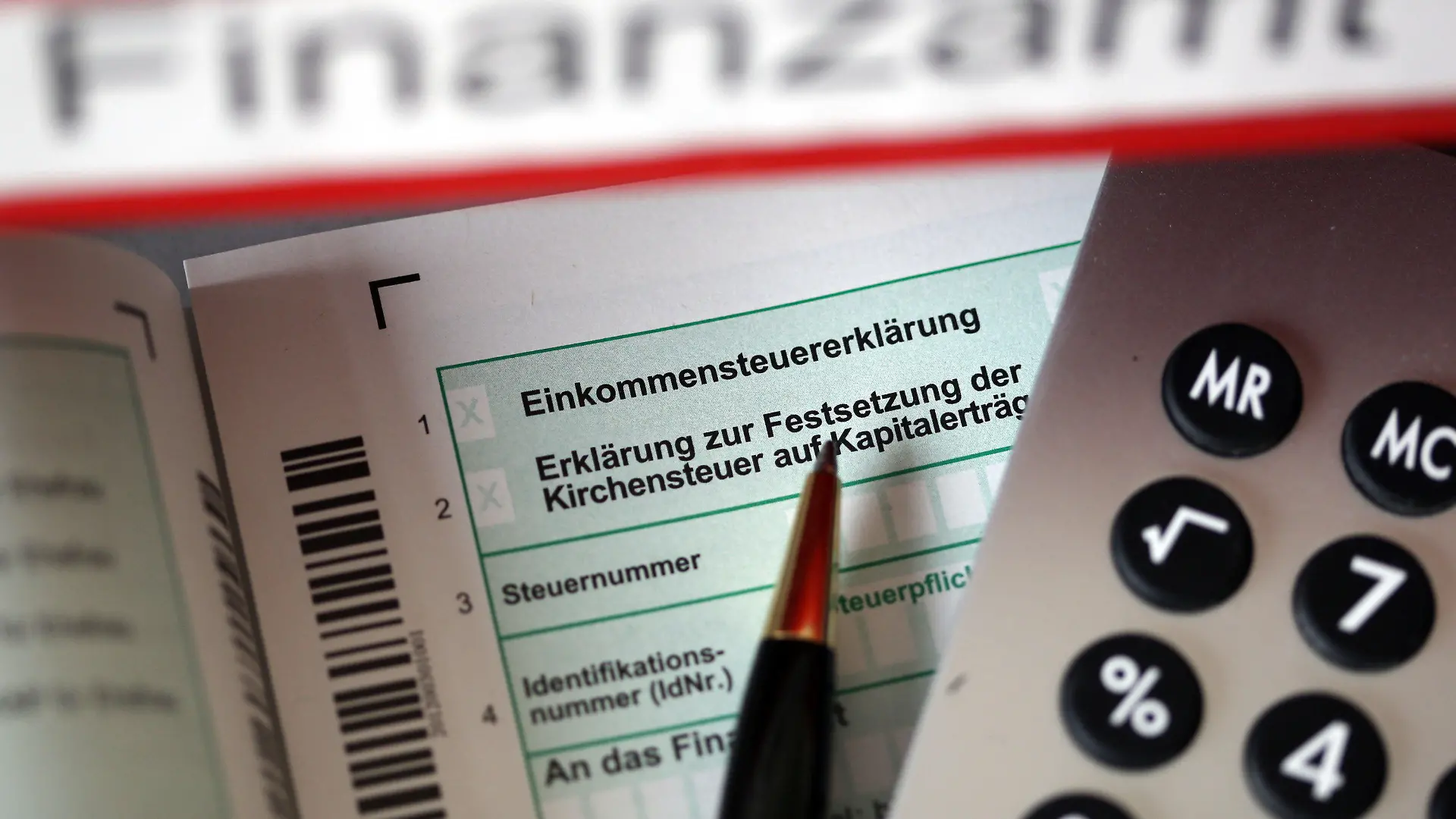 ARCHIV - ILLUSTRATION - Auf einem Vordruck für Einkommnssteuererklärung liegt am 20.11.2013 in Köln (Nordrhein-Westfalen) vor dem Aktenordner Finanzamt ein Stift und eine Brille. Am Dienstag erläutert NRW-Finanzminister Walter-Borjans (SPD) auf einer Pressekonferenz das Thema «Klartext imSteuerbescheid». Foto: Oliver Berg/dpa +++(c) dpa - Bildfunk+++
