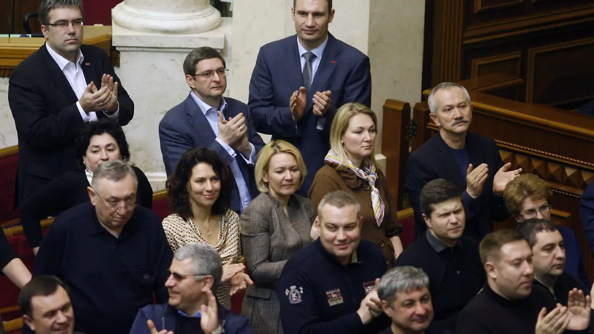 epa04093499 Deputies of UDAR faction with their leader Vitaly Klitschko (C, background) applaud reached agreement between opposition and president Yanukovych during a session of Verkhovna Rada (Ukrainian parliament) in Kiev, Ukraine, 21 February 2014. Riot police has left government and parliament area. Shortly after the signing, parliament voted in favour of restoring a 2004 constitution that limits the powers of the president and approved an amnesty. The deal, which was published on the website of the German Foreign Ministry, calls for the formation of a national unity government within ten days and for early presidential elections no later than December. Yanukovych's term ends in March 2015. EPA/YURI MAXIMOV +++(c) dpa - Bildfunk+++