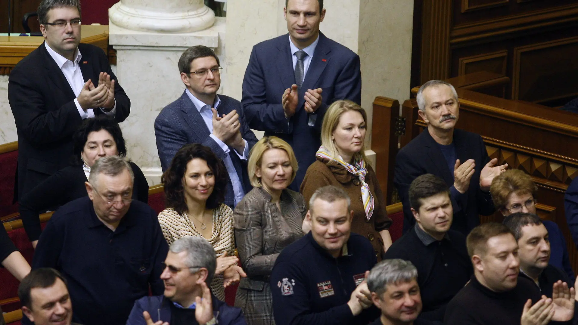 epa04093499 Deputies of UDAR faction with their leader Vitaly Klitschko (C, background) applaud reached agreement between opposition and president Yanukovych during a session of Verkhovna Rada (Ukrainian parliament) in Kiev, Ukraine, 21 February 2014. Riot police has left government and parliament area. Shortly after the signing, parliament voted in favour of restoring a 2004 constitution that limits the powers of the president and approved an amnesty. The deal, which was published on the website of the German Foreign Ministry, calls for the formation of a national unity government within ten days and for early presidential elections no later than December. Yanukovych's term ends in March 2015. EPA/YURI MAXIMOV +++(c) dpa - Bildfunk+++