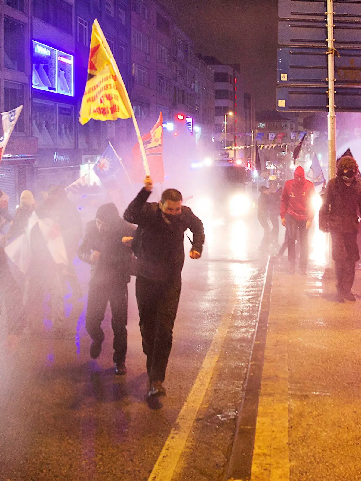 Protesters run away from water cannon and tear gas used by riot police during a demonstration against Turkey's Prime Minister Tayyip Erdogan in Istanbul February 25, 2014. Riot police fired water cannon and tear gas to disperse several thousand protesters chanting "thief Tayyip Erdogan" and "government resign" in Istanbul on Tuesday as the fallout of a corruption scandal intensified. The protest in the Kadikoy district of Istanbul came after Erdogan accused political enemies of faking a recording of a phone conversation suggesting he had warned his son to hide large sums of money as the graft inquiry erupted. REUTERS/Cevahir Bugu (TURKEY - Tags: POLITICS CIVIL UNREST CRIME LAW)