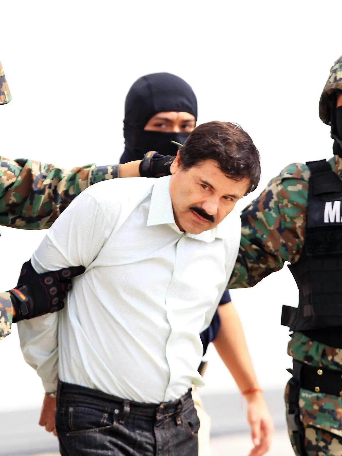epaselect epa04096602 Mexican military hold Mexican drug lord Joaquin Guzman Loera, alias 'El Chapo' (C) at the Navy hangar in Mexico City, Mexico, 22 February 2014. The head of the Sinaloa drug cartel Joaquin 'El Chapo' Guzman was arrested on 22 February 2014 in Mazatlan in the Mexican state of Sinaloa. Reputed to be 'the most powerful drug trafficker in the world' by the United States, Guzman had been on the run for years. EPA/MARIO GUZMAN +++(c) dpa - Bildfunk+++