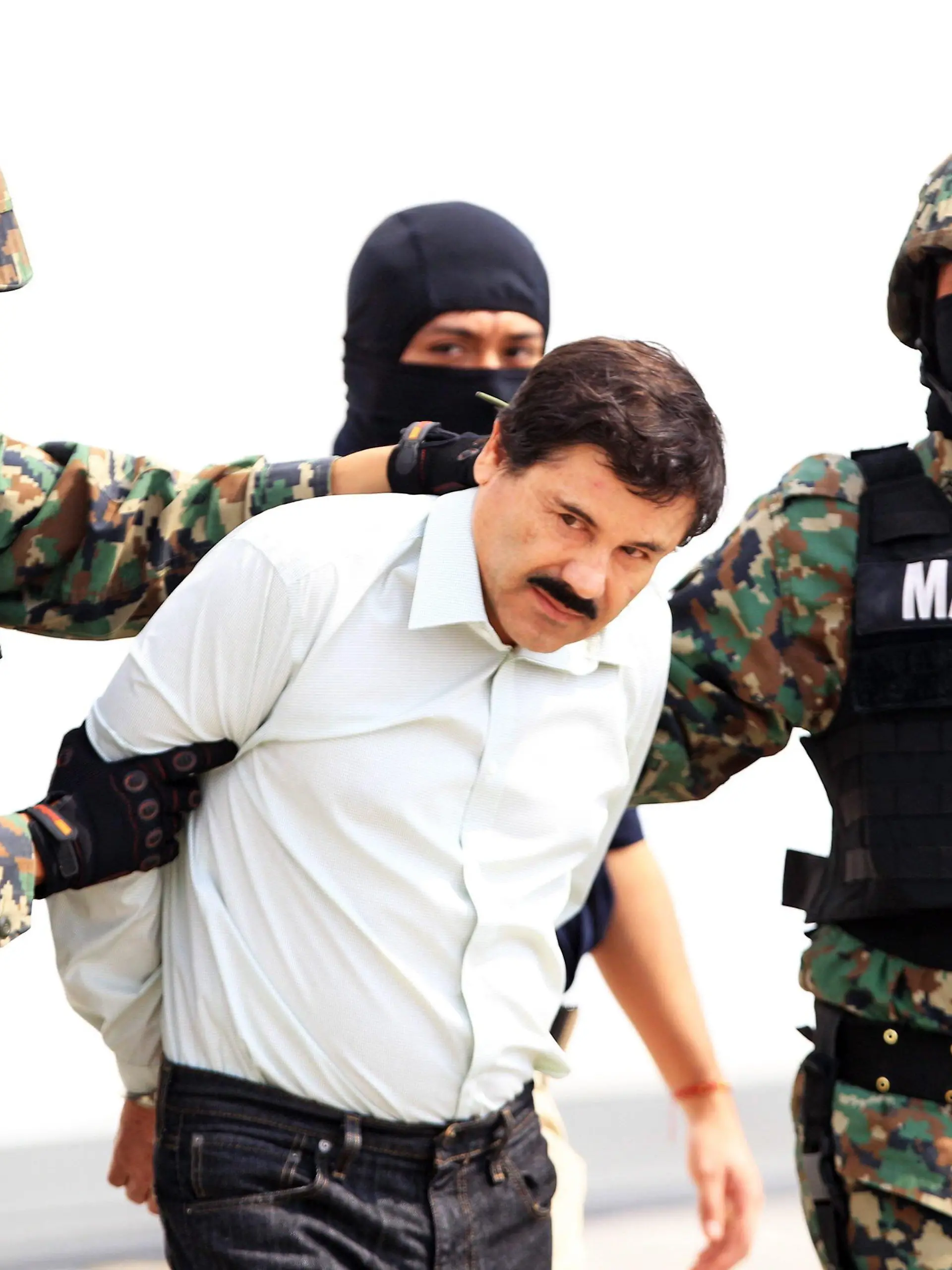 epaselect epa04096602 Mexican military hold Mexican drug lord Joaquin Guzman Loera, alias 'El Chapo' (C) at the Navy hangar in Mexico City, Mexico, 22 February 2014. The head of the Sinaloa drug cartel Joaquin 'El Chapo' Guzman was arrested on 22 February 2014 in Mazatlan in the Mexican state of Sinaloa. Reputed to be 'the most powerful drug trafficker in the world' by the United States, Guzman had been on the run for years. EPA/MARIO GUZMAN +++(c) dpa - Bildfunk+++