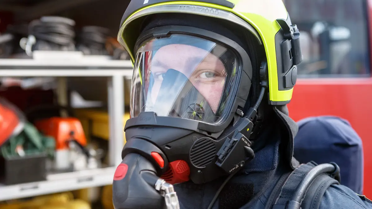Ein Mitglied der Freiwilligen Feuerwehr posiert bei einer Übung am 02.02.2014 in Timmendorfer Strand (Schleswig-Holstein) vor einem Einsatzfahrzeug. Sein Helm mit integriertem Sprechfunk und der Atemschutz sind Produkte der Firma Dräger aus Lübeck, die dort am 06.02.2014 ihr 125 jähriges Firmenjubiläum feiert. Foto: Markus Scholz/dpa +++(c) dpa - Bildfunk+++