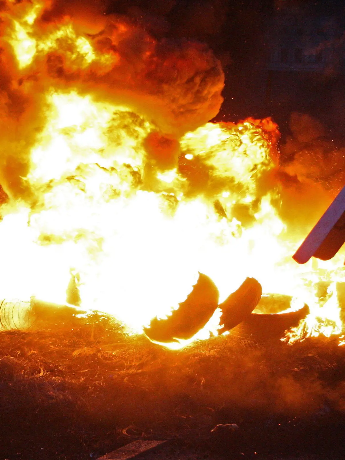 epa04091483 Ukrainian opposition activist throws a tyre to feed burning fire barricade after cruel clashes with riot police earlier today in Kiev, Ukraine, 20 February 2014. At least 39 people people were killed during in street fighting in Kiev on 20 February, the Ukrainian Health Ministry said. The ministry said that 67 people had died since 18 February. The Ukrainian police force has been given combat weapons for use in the civil unrest in Kiev, Interior Minister Vitaliy Zakharchenko says. Fresh fighting broke out between thousands of protesters and riot police on Kiev's Independence Square only hours after opposition leaders and President Viktor Yanukovych declared a truce. Protesters were seen throwing firebombs and molotov cocktails at police, who responded with teargas. The square was filled with black smoke from burning tires. EPA/IGOR KOVALENKO +++(c) dpa - Bildfunk+++