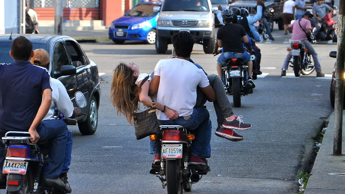 epa04089786 A handout picture provided by daily Notitarde on 19 February 2014 shows a man on a motorcycle moving Venezuelan beauty queen and student Genesis Carmona after she was injured by a bullet wound to the head during a protest against Venezuelan government on 18 February 2014, in Valencia, Venezuela. One of the doctors who treated her confirmed her death on 19 February 2014. EPA/Mauricio Centeno / Notitarde HANDOUT EDITORIAL USE ONLY/NO SALES +++(c) dpa - Bildfunk+++