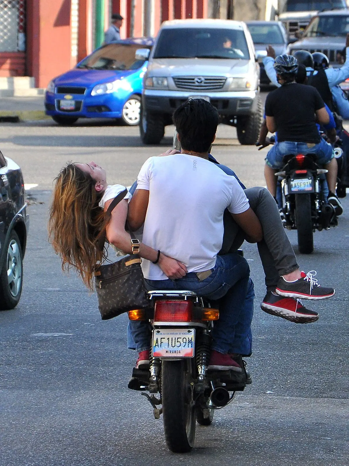 epa04089786 A handout picture provided by daily Notitarde on 19 February 2014 shows a man on a motorcycle moving Venezuelan beauty queen and student Genesis Carmona after she was injured by a bullet wound to the head during a protest against Venezuelan government on 18 February 2014, in Valencia, Venezuela. One of the doctors who treated her confirmed her death on 19 February 2014. EPA/Mauricio Centeno / Notitarde HANDOUT EDITORIAL USE ONLY/NO SALES +++(c) dpa - Bildfunk+++