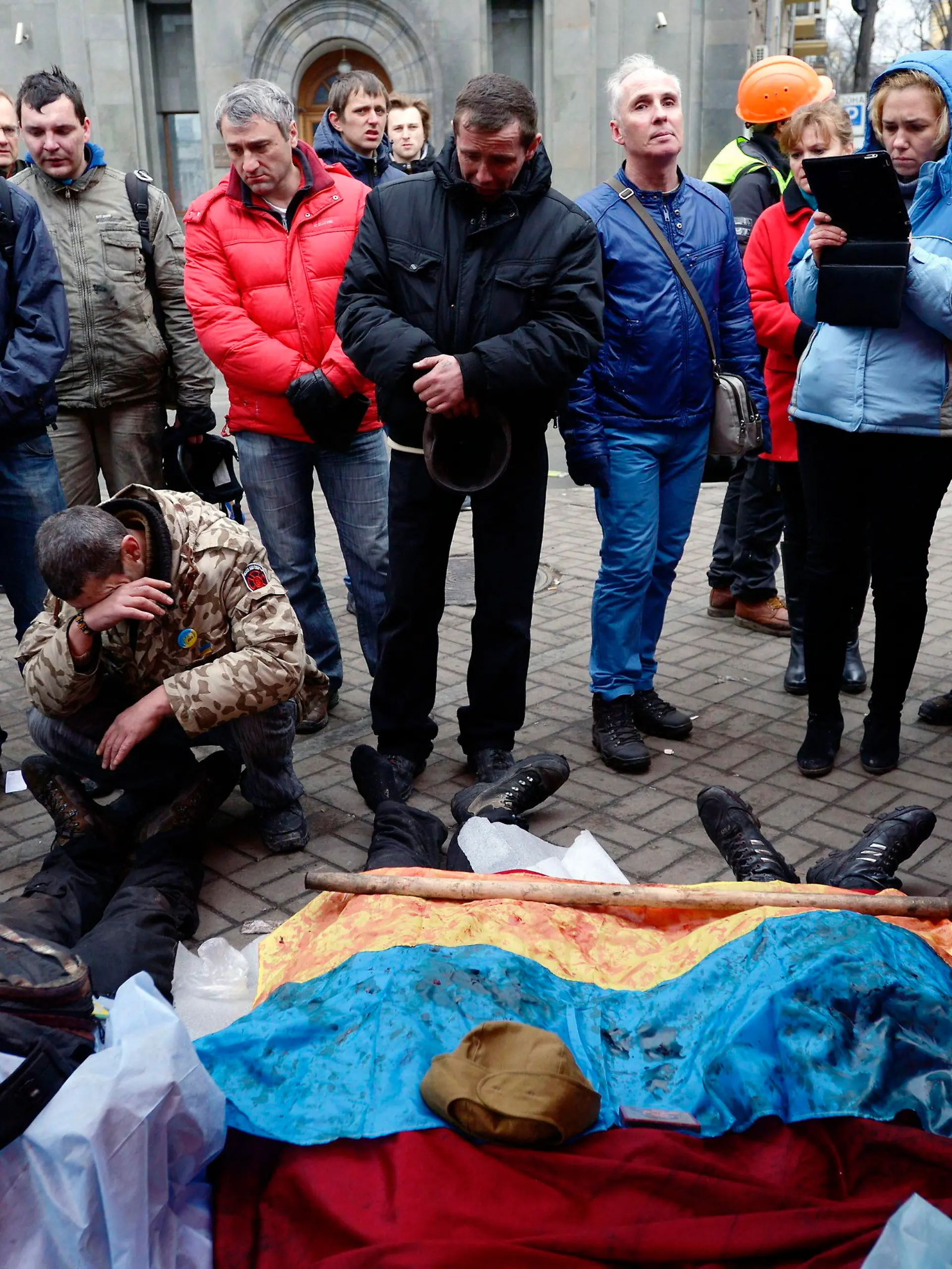 epa04090926 Activists pay respects to protesters killed in clashes with police in Kiev, Ukraine, 20 February 2014. More than 60 people have been killed in street fighting in Kiev on Thursday, the nationalist Svoboda opposition party says. The Ukrainian police force has been given combat weapons for use in the civil unrest in Kiev, Interior Minister Vitaliy Zakharchenko says. Fresh fighting broke out between thousands of protesters and riot police on Kiev's Independence Square only hours after opposition leaders and President Viktor Yanukovych declared a truce. Protesters were seen throwing firebombs and molotov cocktails at police, who responded with teargas. The square was filled with black smoke from burning tyres. EPA/LASZLO BELICZAY ATTENTION EDITORS: GRAPHIC CONTENT +++(c) dpa - Bildfunk+++