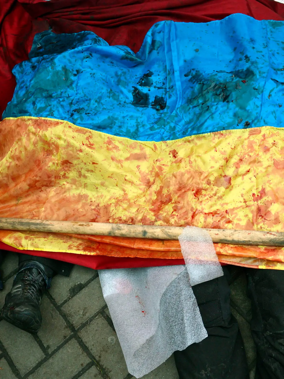 epa04090925 A bloody Ukranian flag covers the bodies of killed protesters in Kiev, Ukraine, 20 February 2014. More than 60 people have been killed in street fighting in Kiev on Thursday, the nationalist Svoboda opposition party says. The Ukrainian police force has been given combat weapons for use in the civil unrest in Kiev, Interior Minister Vitaliy Zakharchenko says. Fresh fighting broke out between thousands of protesters and riot police on Kiev's Independence Square only hours after opposition leaders and President Viktor Yanukovych declared a truce. Protesters were seen throwing firebombs and molotov cocktails at police, who responded with teargas. The square was filled with black smoke from burning tyres. EPA/LASZLO BELICZAY ATTENTION EDITORS: GRAPHIC CONTENT +++(c) dpa - Bildfunk+++