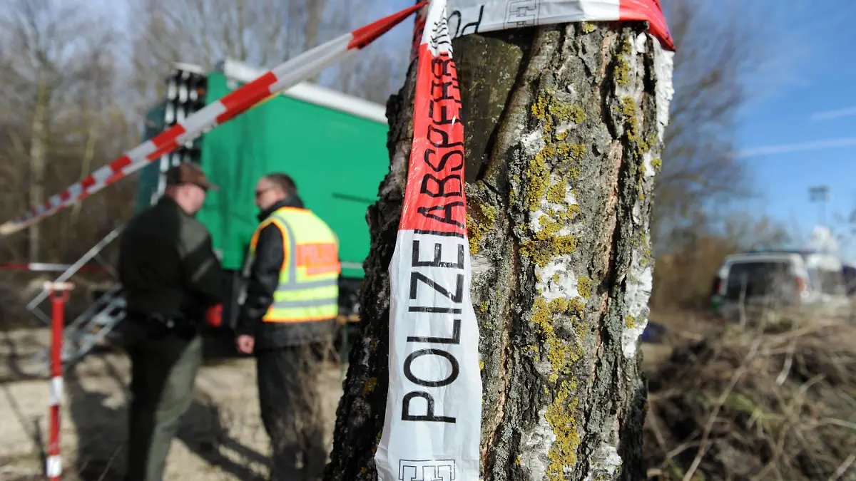 Ein Absperrband der Polizei hängt am 17.02.2014 an einem Baum am Rathei-Weiher zwischen Zell und Karlshuld bei Neuburg a.d. Donau (Bayern), wo Spaziergänger am Vortag eine Leiche gefunden haben. Ein zwölfjähriges Mädchen ist dort Opfer eines Gewaltverbrechens geworden. Ein Verdächtiger wurde festgenommen, schweigt aber. Foto: Andreas Gebert/dpa +++(c) dpa - Bildfunk+++