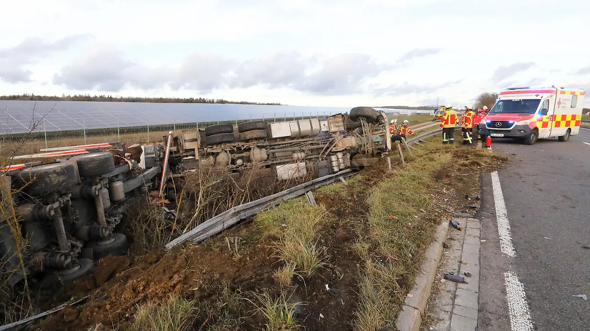 27.12.2022, Baden-Württemberg, Ehingen: Ein Lastwagen liegt nach einer Kollision mit einem PKW neben der Bundesstraße 311 zwischen Ehingen und Munderkingen im Graben an der beschädiggten Leitplanke. Bei der Kollision wurden zwei Menschen getötet, zwei weitere Personen wurden verletzt. Foto: Thomas Warnack/dpa +++ dpa-Bildfunk +++