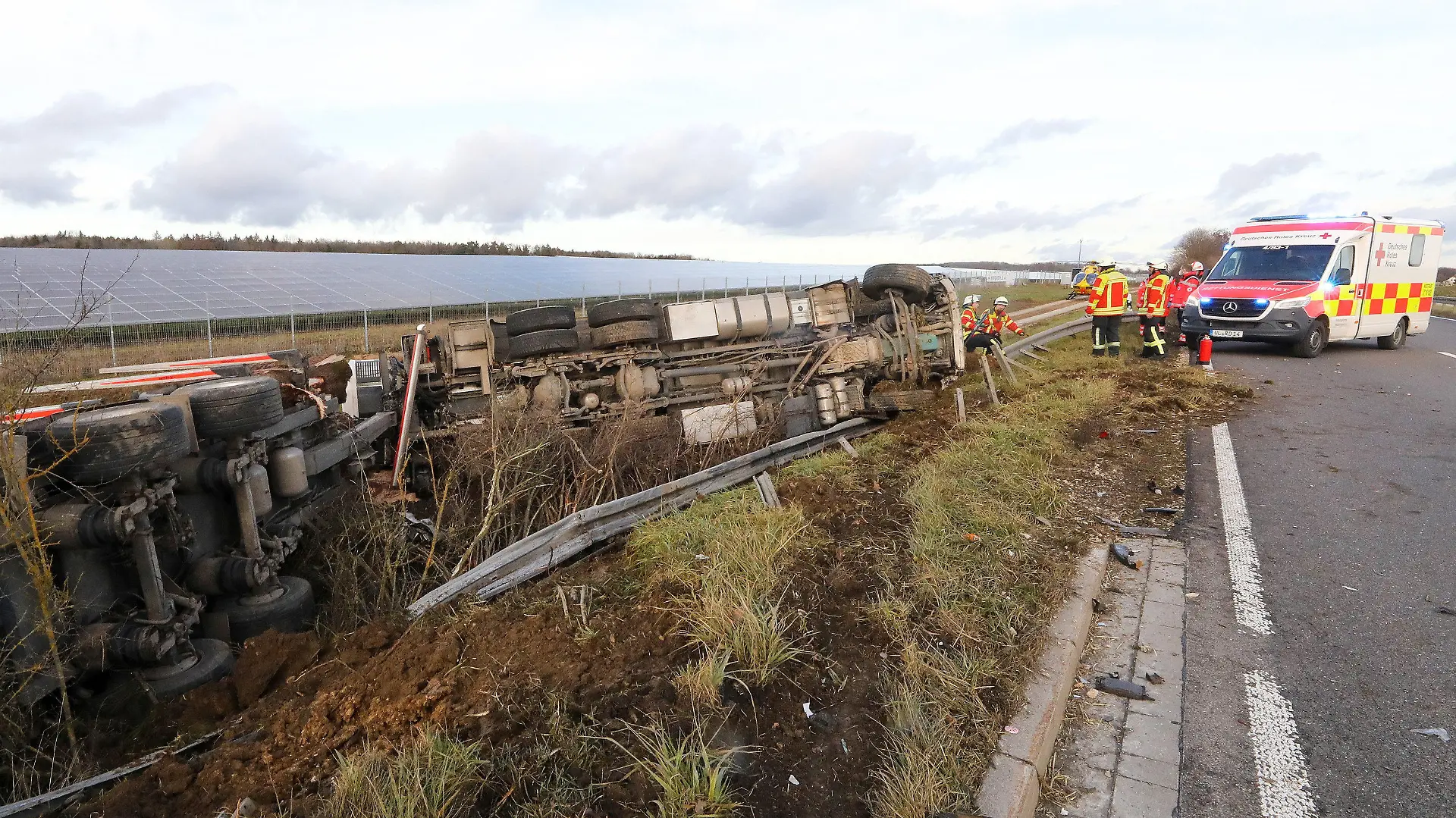27.12.2022, Baden-Württemberg, Ehingen: Ein Lastwagen liegt nach einer Kollision mit einem PKW neben der Bundesstraße 311 zwischen Ehingen und Munderkingen im Graben an der beschädiggten Leitplanke. Bei der Kollision wurden zwei Menschen getötet, zwei weitere Personen wurden verletzt. Foto: Thomas Warnack/dpa +++ dpa-Bildfunk +++