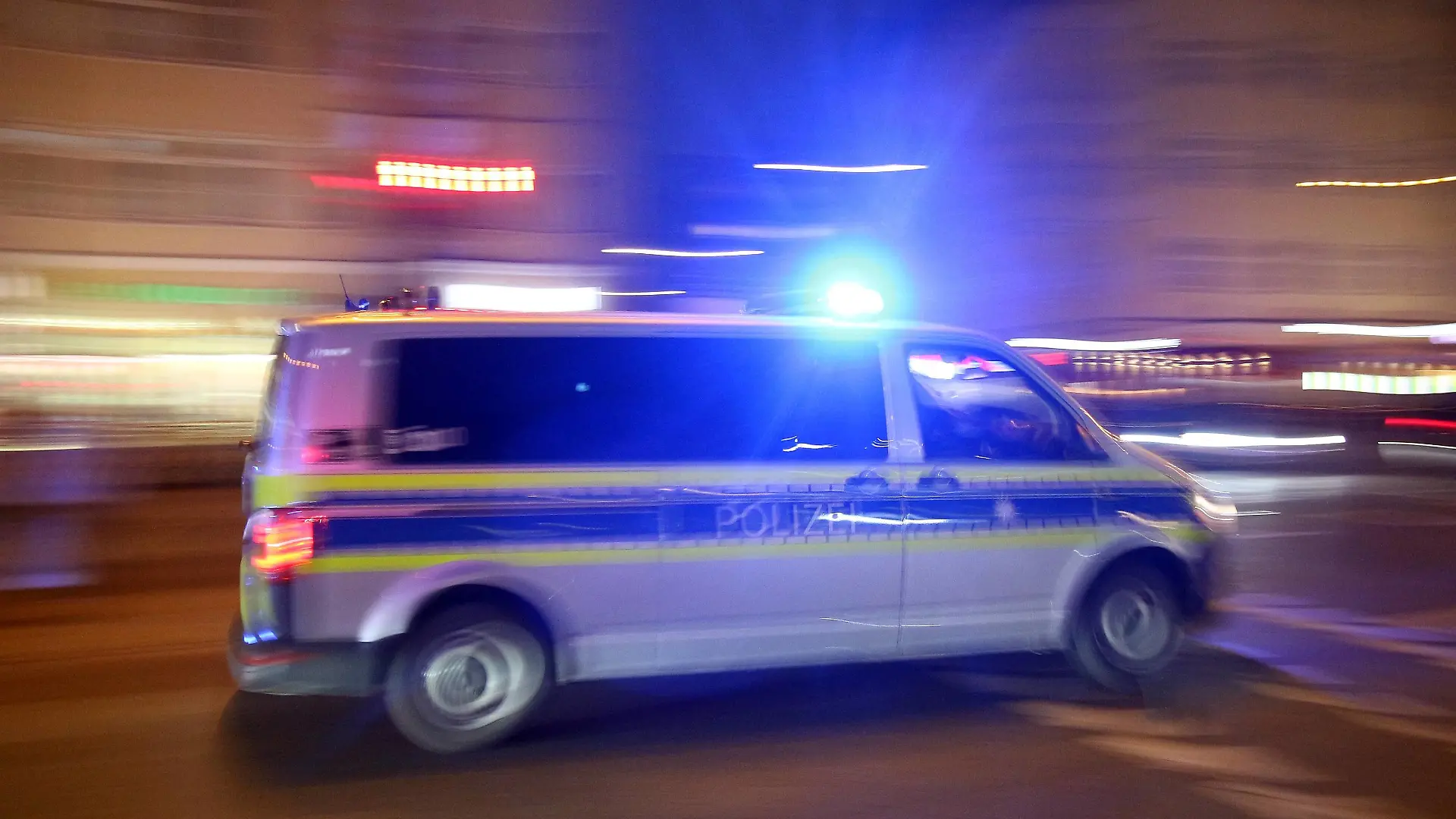 Einsatzwagen der Polizei mit eingeschaltetem Blaulicht bei einem Einsatz in München am Abend, Bayern, Deutschland *** Racing car of the police with the blue light on a mission in Munich on the night of Bavaria Germany
