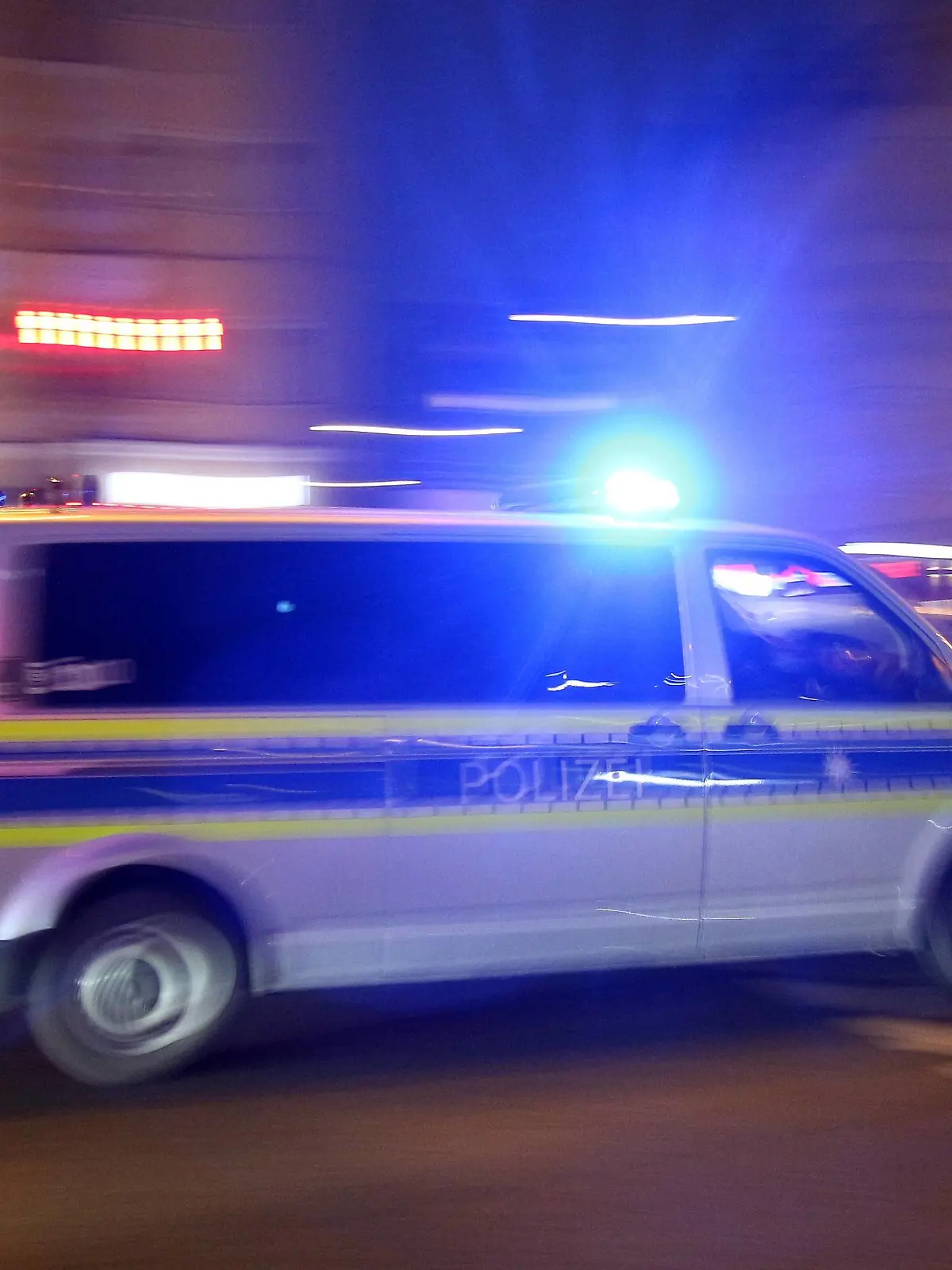 Einsatzwagen der Polizei mit eingeschaltetem Blaulicht bei einem Einsatz in München am Abend, Bayern, Deutschland *** Racing car of the police with the blue light on a mission in Munich on the night of Bavaria Germany  