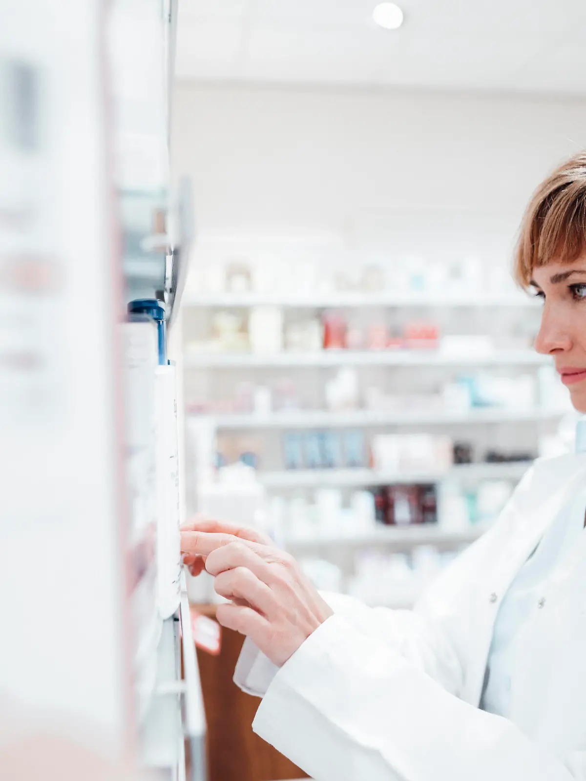  Female pharmacist searching medicine at pharmacy model released Symbolfoto property released JOSEF05446