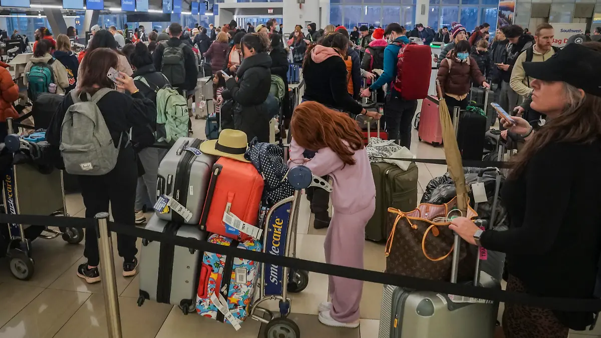 23.12.2022, USA, New York: Passagiere von Southwest Airlines stehen wegen Verspätungen und Flugausfällen am Laguardia Airport Schlange. Foto: Bebeto Matthews/AP/dpa +++ dpa-Bildfunk +++