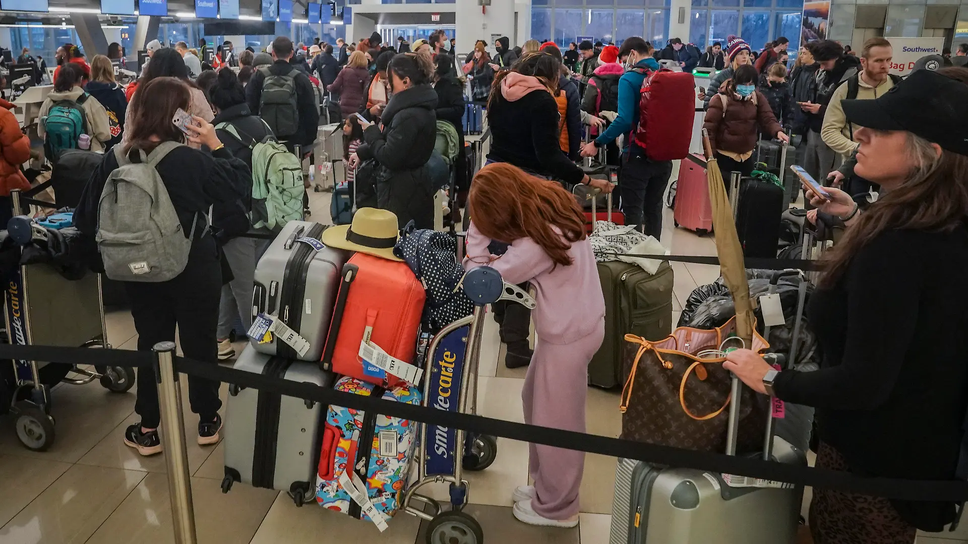 23.12.2022, USA, New York: Passagiere von Southwest Airlines stehen wegen Verspätungen und Flugausfällen am Laguardia Airport Schlange. Foto: Bebeto Matthews/AP/dpa +++ dpa-Bildfunk +++