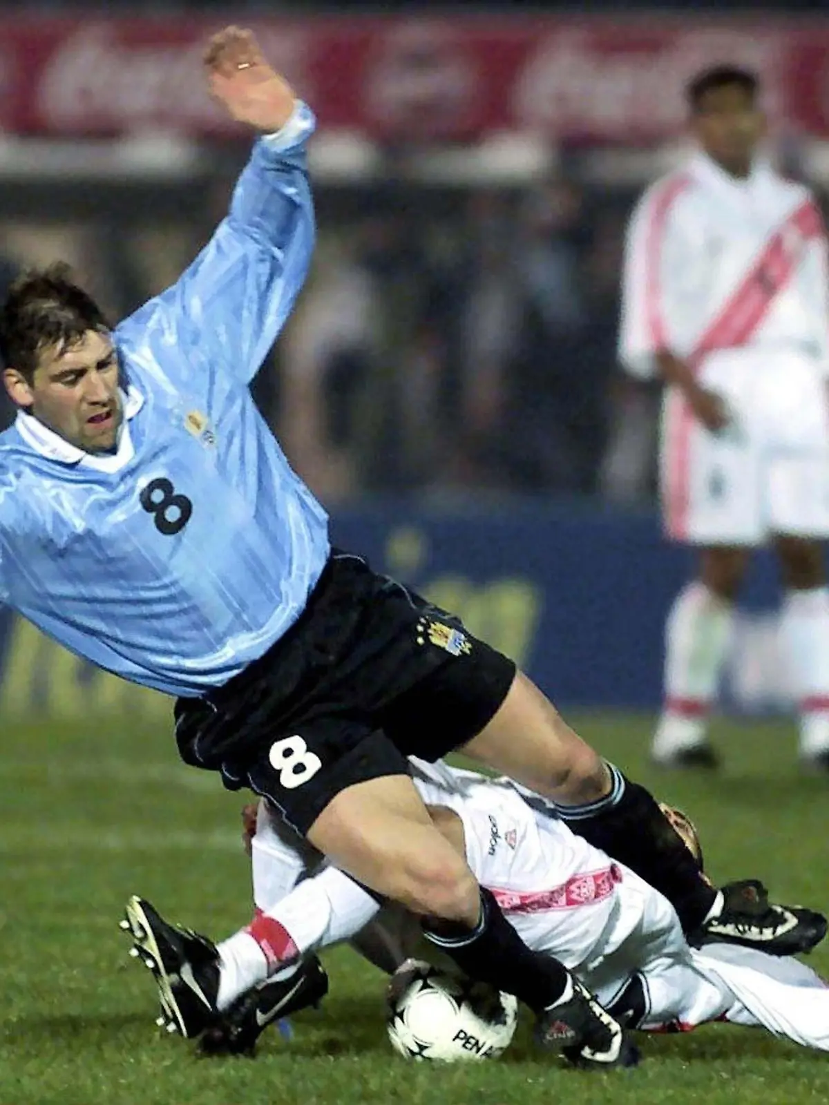 Uruguays Spieler Fabian O'Neill (oben) wird von einem nicht identifizierten peruanischen Gegenspieler gestoppt. Die Fußballnationalmannschaften von Uruguay und Peru trennen sich am 26.07.2000 im WM-Qualifikationsspiel im Centenario-Stadion in Montevideo torlos.