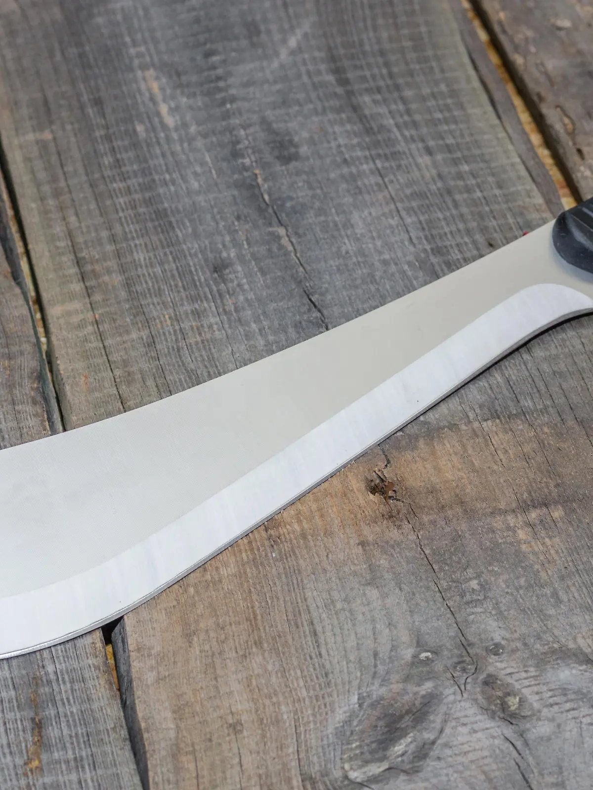 A Latin American knife for clearing roads. Photo at an angle. Wooden background.