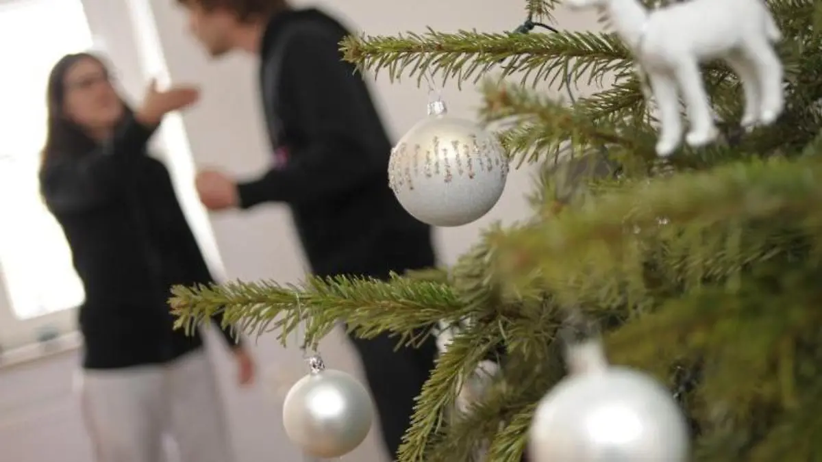 Wenn die Familie sich um den Weihnachtsbaum schart, kracht es schnell. Weniger Erwartungsdruck kann helfen, Streit zu vermeiden. Foto: Andreas Gebert