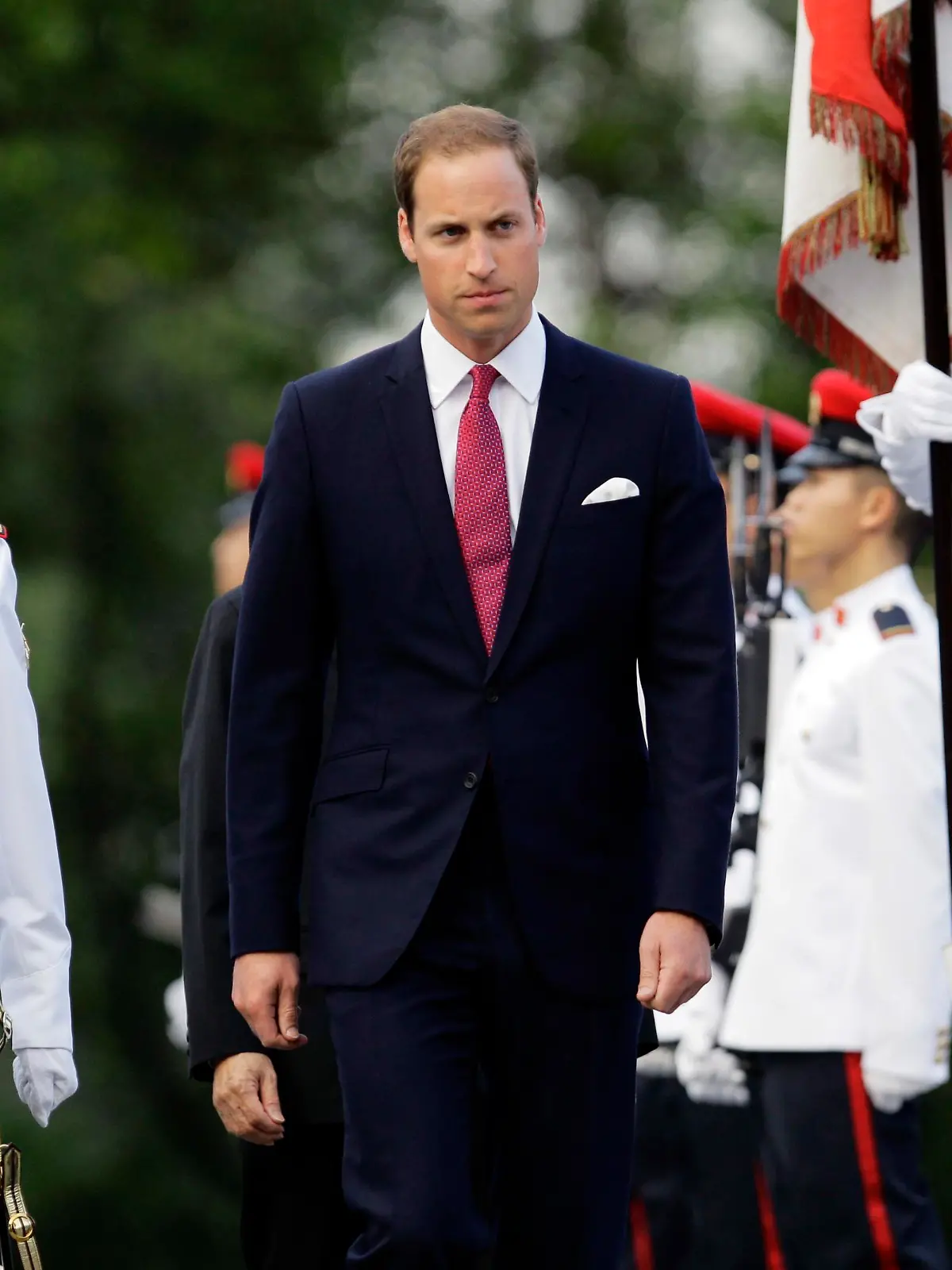 Britain's Prince William (C) inspects an honour guard during a welcoming ceremony at the Istana presidential palace in Singapore September 11, 2012. Prince William and Catherine, Duchess of Cambridge, are in the city-state for a three-day visit as part of a tour to mark Queen Elizabeth II's Diamond Jubilee. REUTERS/Tim Chong (SINGAPORE - Tags: ROYALS ENTERTAINMENT POLITICS)