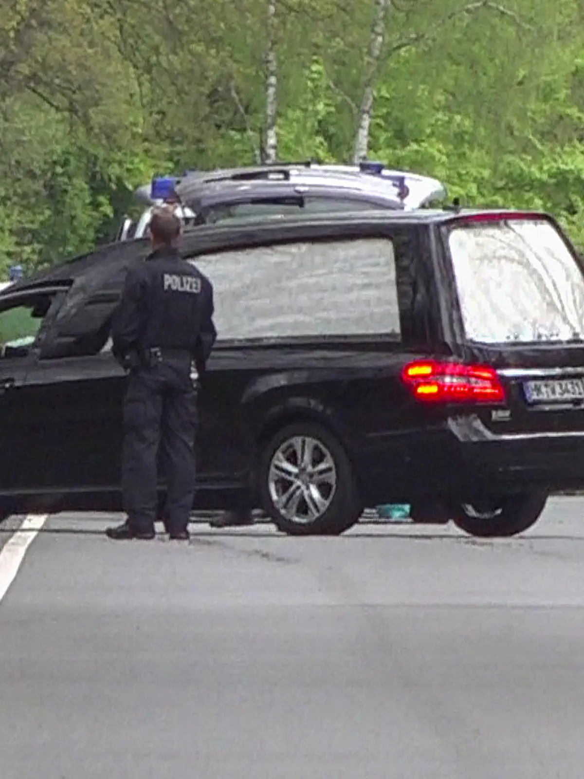 18.05.2021, Niedersachsen, Bispingen: In einem Waldstück unweit von Bispingen fährt ein Leichenwagen von der Bundesstraße in den Wald. Dort wurde eine Kinderleiche gefunden. Eine Frau und ihr vierjähriger Sohn waren am 16. Mai tot in einem Haus in Bispingen entdeckt worden. Beide hätten Spuren von Gewalt aufgezeigt, teilten Polizei und Staatsanwaltschaft mit. Die elfjährige Tochter wurde vermisst. Foto: Tnn/dpa +++ dpa-Bildfunk +++