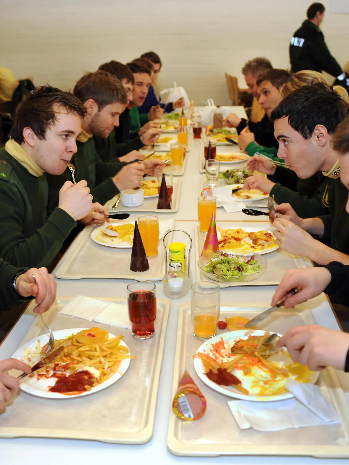 Polizeibeamte sitzen beim Mittagessen in der Kantine der Bereitschaftspolizei in Lahr (Ortenaukreis) (Foto vom 14.01.2009). Der NATO-Gipfel Anfang April am Oberrhein wird für die Polizei eine logistische Herausforderung. Benötigt werden nicht nur Streifenwagen und Absperrgitter. Auch Lebensmittel und Hotelbetten müssen organisiert werden. Damit die mindestens 14 000 Polizisten genügend Kraft für ihren Einsatz haben, müssen sie verpflegt und untergebracht werden. Foto: Rolf Haid dpa/lsw (zu lsw-Korr 7039 vom 11.02.2009) +++(c) dpa - Report+++