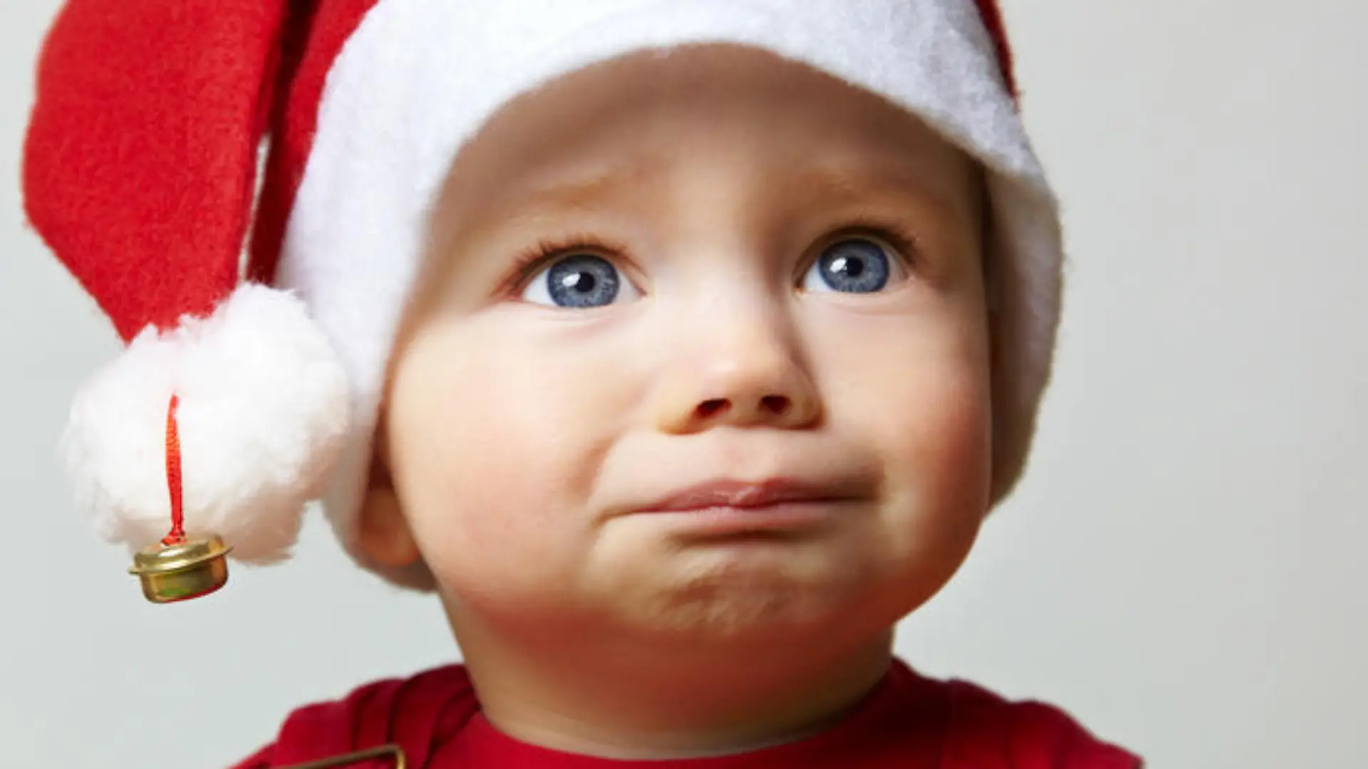 Trauriges Kind mit roter Weihnachtsmütze an Weihnachten