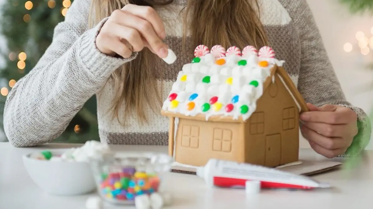 Young woman preparing gingerbread house || Modellfreigabe vorhanden