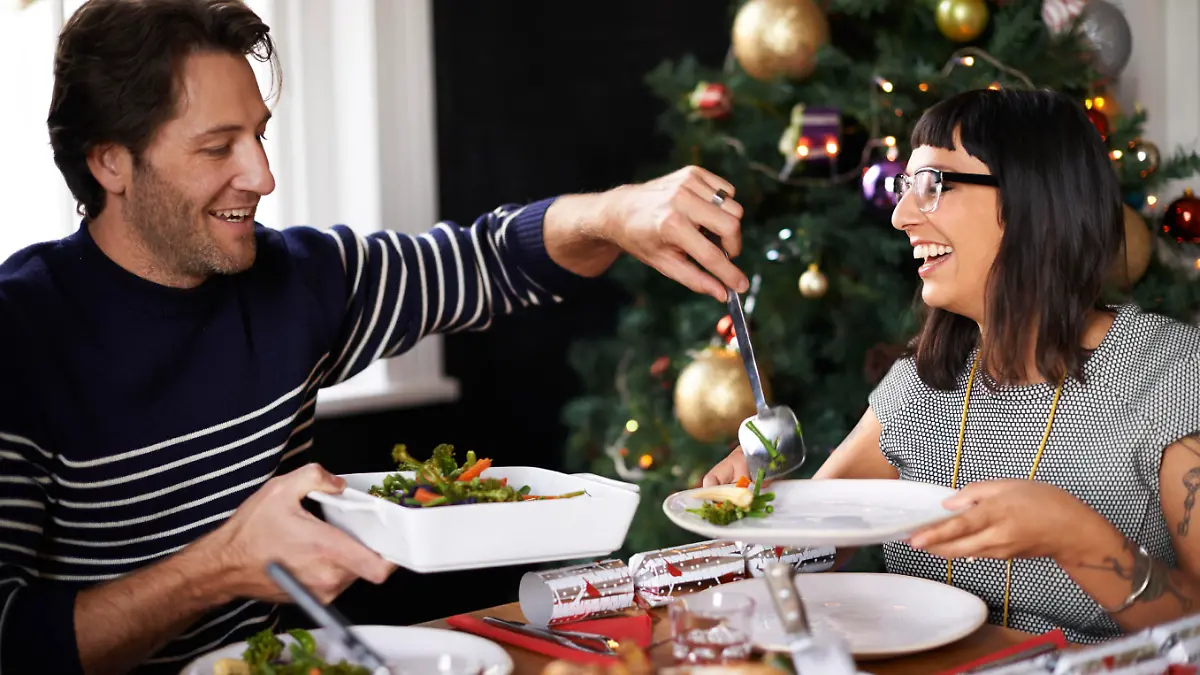 Shot of a happy young couple eating Christmas dinner