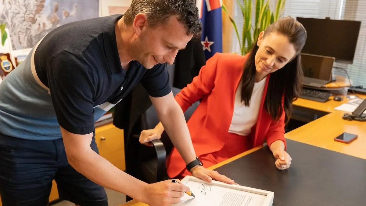 HANDOUT - 31.03.2021, Neuseeland, Wellington: David Seymour, Vorsitzender der rechtsliberalen ACT-Partei, und Jacinda Ardern, Neuseelands Premierministerin, unterschreiben einen Ausdruck des Hansard (offizielles Parlamentsprotokoll), in dem Ardern Seymour als «arroganten Arsch» bezeichnet. Der Ausdruck wird versteigert, um Geld für die Prostatakrebsstiftung zu sammeln. (zu dpa «Versöhnliches Ende nach peinlicher Mikrofon-Panne in Neuseeland») Foto: ACT Party/dpa - ACHTUNG: Nur zur redaktionellen Verwendung im Zusammenhang mit der aktuellen Berichterstattung und nur mit vollständiger Nennung des vorstehenden Credits +++ dpa-Bildfunk +++